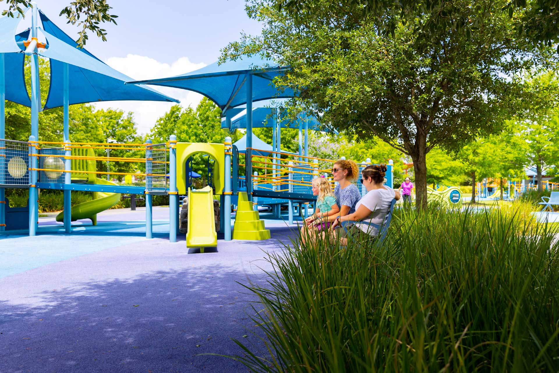 a group of people sitting on a bench at a playground