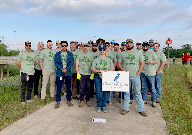 GBC Tree Planting 8 Group of volunteers pose for a photo holding a Greens Bayou Coalition sign during a community tree planting and environmental restoration event.