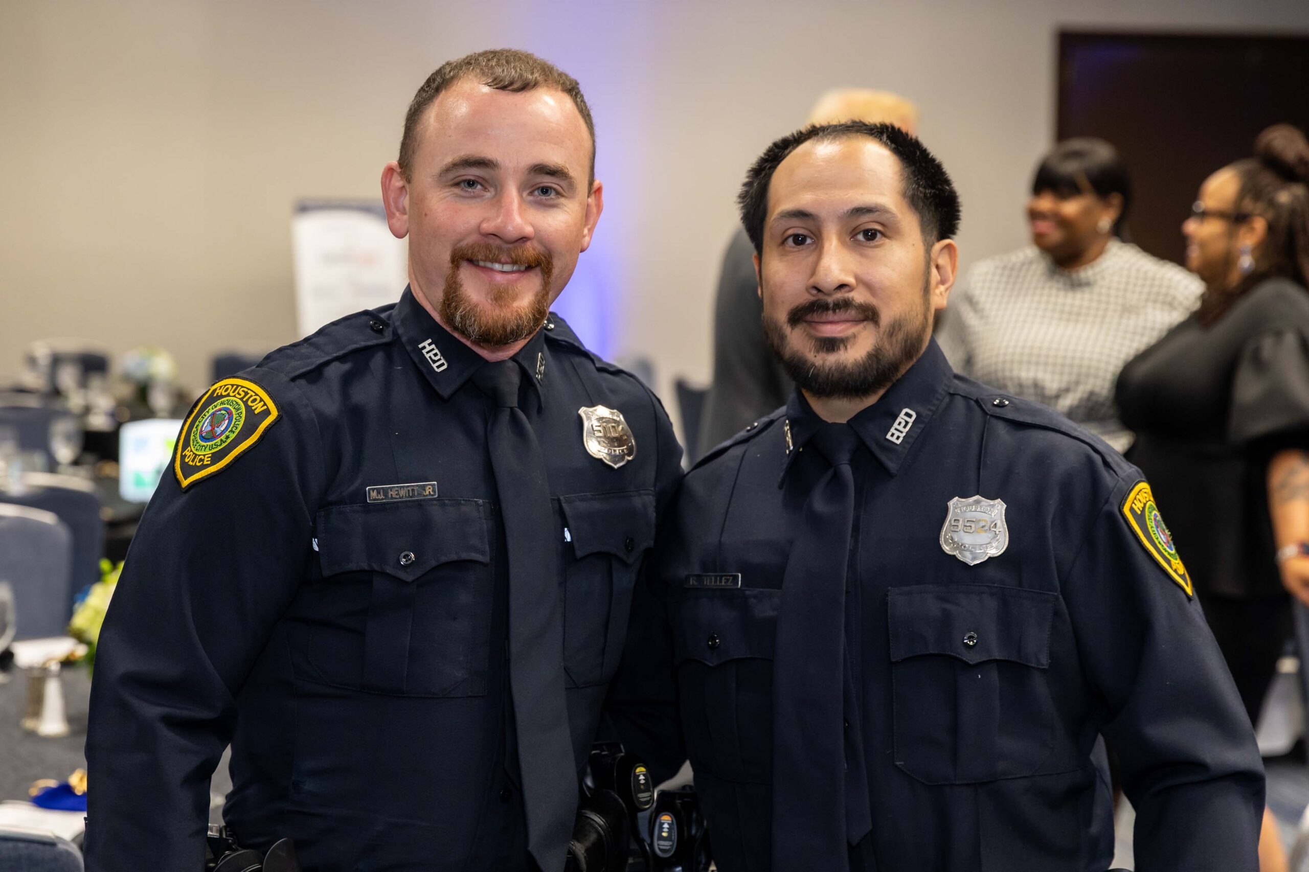 Two uniformed officers pose together and smile at the camera during the luncheon.