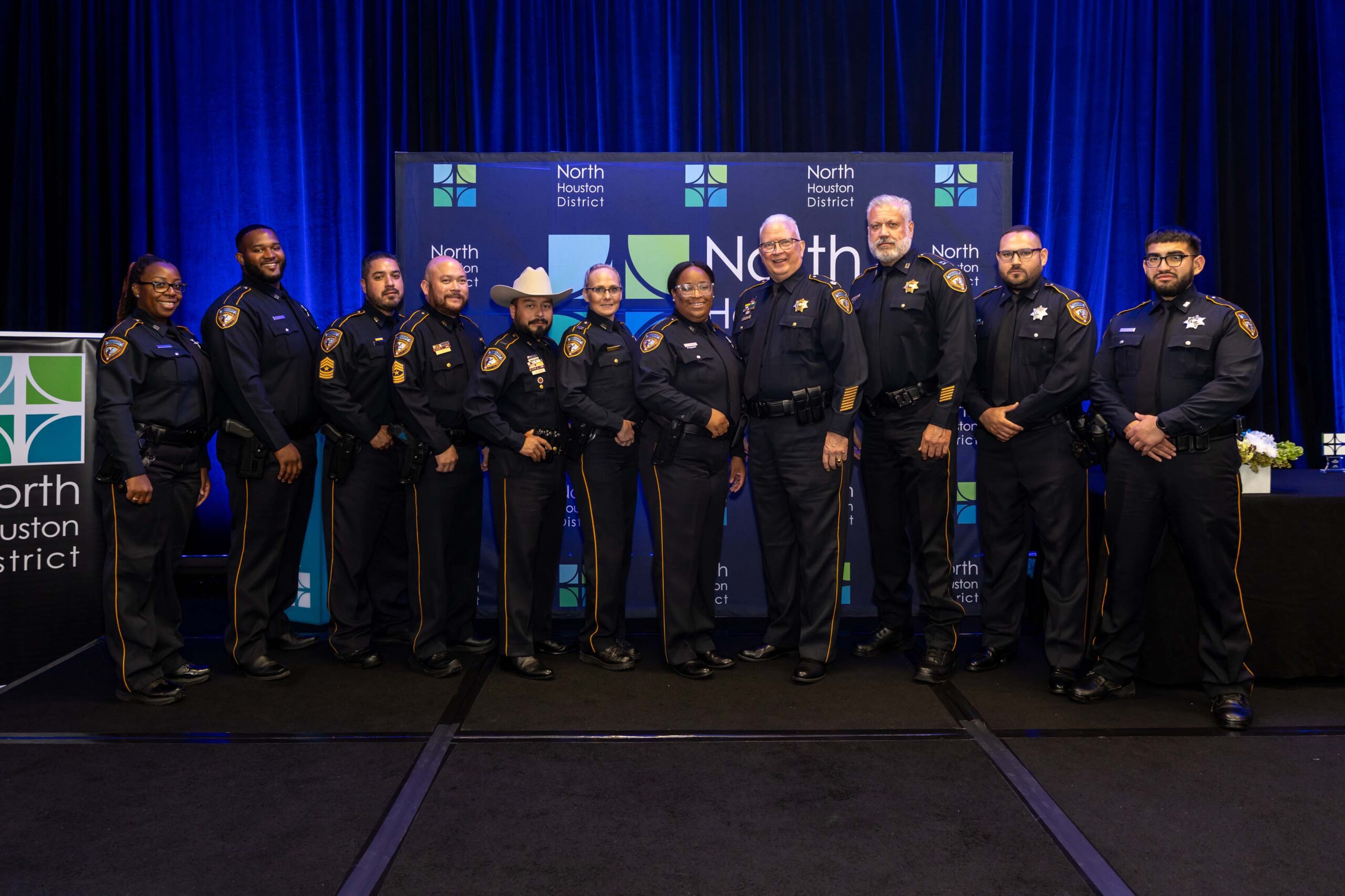 Twelve law enforcement officers from the Harris County Sheriff’s Office stand on stage in full uniform for a group photo at the 2025 Public Safety Awards.