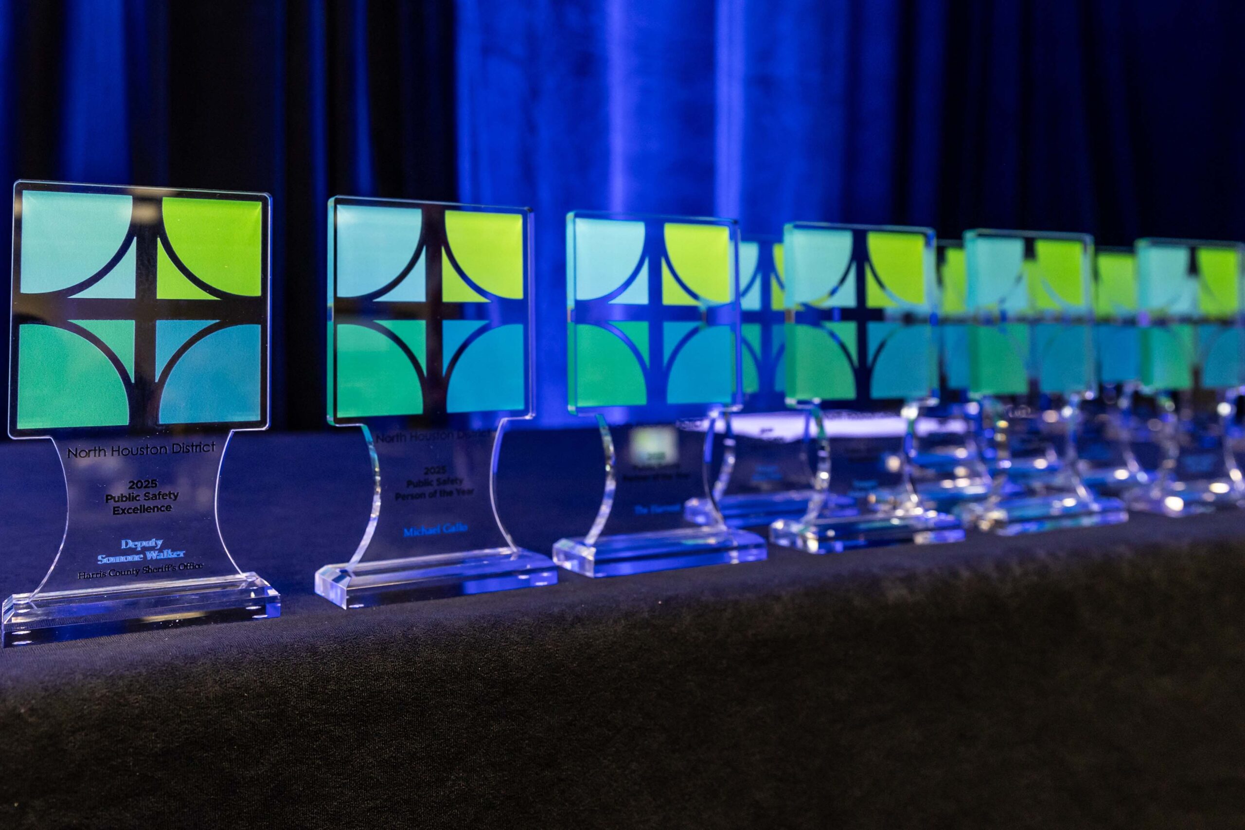 Close-up of colorful North Houston District awards arranged on a black tablecloth.