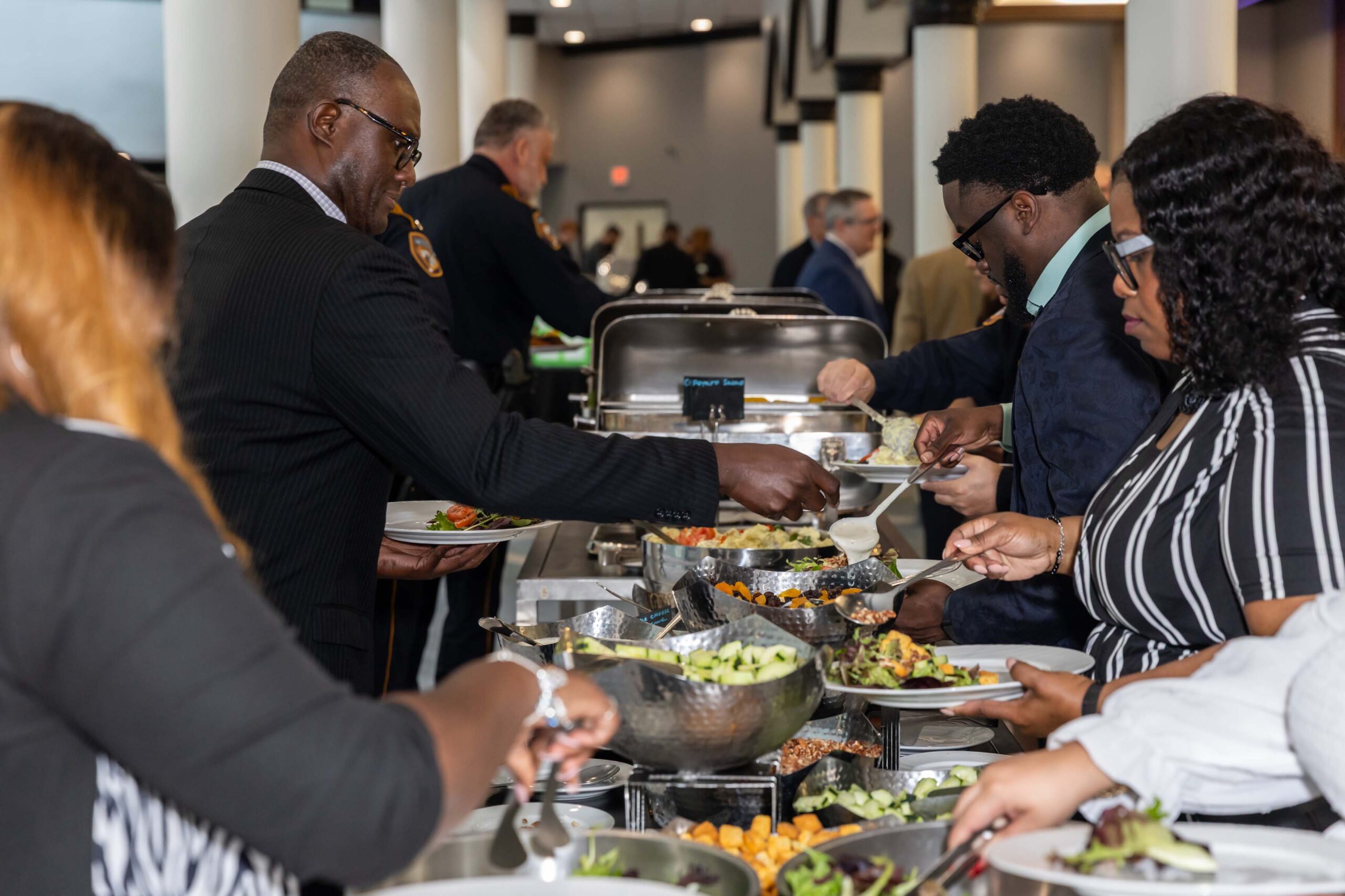 Guests serve themselves salad and sides from a buffet line.