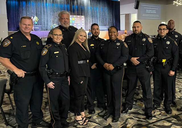 Captain Sandra Chapa poses with fellow officers and Tracy Harrison, North Houston District Public Safety Vice President, at the Public Safety Awards Luncheon, celebrating service and dedication in a formal event space.